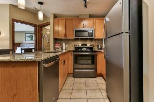 坎莫尔B&B Falcon Crest Lodge 1BR 1Pullout的厨房配有不锈钢用具和木柜