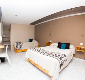 埃尔卡拉法特Amigo del Mundo Hostería y Apart Hotel的酒店客房设有两张床和一张桌子。