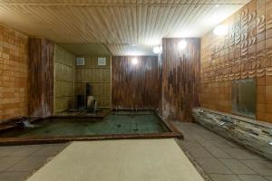 丰冈市森穗酒店的空虚的浴室设有木制墙壁和淋浴