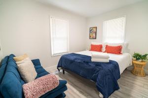 坦帕Homey Cozy Newly Renovated Stylish&chic 7 Guests的一间卧室配有一张床和一张蓝色的沙发