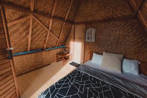 金塔马尼D' Tepi Danau Glamping的木制客房内的一间卧室,配有一张床