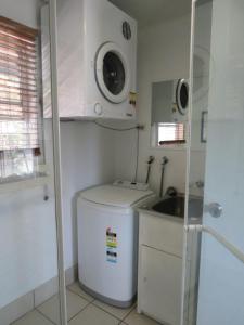 天阁露玛Villa 31 Tangalooma Beach Front的一间带水槽和洗衣机的小浴室