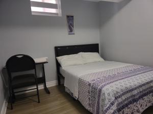 阿贾克斯Prestige Accommodation Self-contained 2 Bedrooms Suite的一间卧室配有一张床、一把椅子和一张书桌