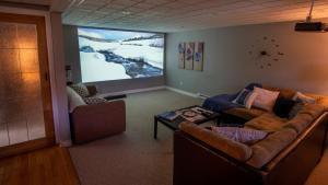 Oak HavenSunset Tides的带沙发和大屏幕的客厅