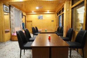 甘托克Matina Regency的一间会议室,配有木墙和桌椅