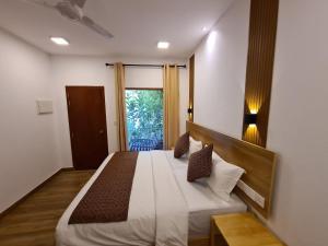 翡诺岛Kihaa Holiday Home的一间卧室设有一张大床和一个窗户。