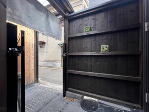 京都至の宿-京都南 Traditional Machiya Guesthouse的木车库门,上面有两架架架子