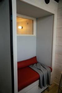 萨拉Salla Wilderness Lodges的一个小衣柜,房间里有一个红色的长凳