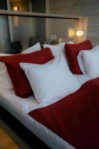 萨拉Salla Wilderness Lodges的一张带红色和白色枕头的床