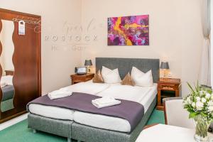 罗斯托克洛斯托克斯达特皮尔酒店的一间卧室配有一张带两张桌子和一幅画的卧室