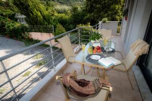 韦里亚Luxury Dafnis House的阳台配有桌椅。