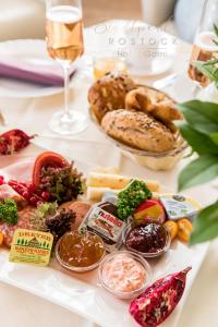 罗斯托克洛斯托克斯达特皮尔酒店的餐桌,包括面包和其他食物以及一杯葡萄酒