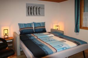 坎德施泰格Energy Lodge的一间卧室配有蓝色和白色床单