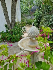 卡斯特拉纳格罗泰Casa di Sofia的在种着粉红色花卉的花园中沐浴鸟