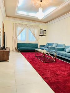 Al FanātīrFANATEER SUDAYER VILLA的带沙发和红色地毯的客厅