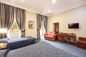 罗马阿托黎斯酒店的酒店客房设有床、椅子和电视