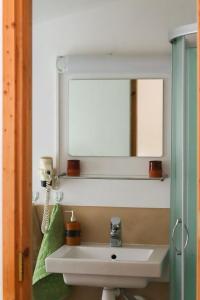 劳拉斯玛Samblatalu Homestay的一间带水槽和镜子的浴室