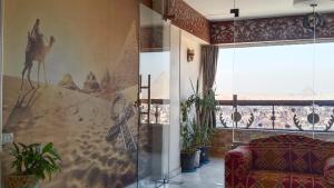 开罗Giza Pyramids View Guest house的客厅配有沙发和墙上的绘画