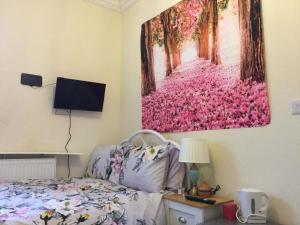 伦敦TDM Bachelot Lettings Ltd的卧室配有一张床,墙上挂有绘画作品