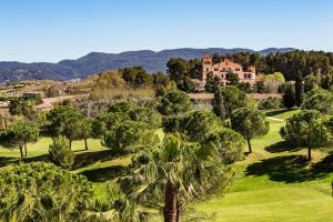 马尔托雷尔Hotel Barcelona Golf Resort 4 Sup的享有被树木环绕的豪宅的空中景致