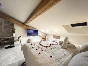 圣艾蒂安Cocon Blanc câlin - Jacuzzi privatif - Love Room à Saint Etienne的一间卧室配有一张玫瑰花大床
