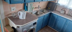 谢普斯敦港Alpero Umtentweni的一个带水槽和洗衣机的小厨房