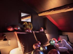圣艾蒂安Suite Privative Rouge baiser - Spa & Jacuzzi - Love Room à Saint Etienne的一间房间,床上放着气球