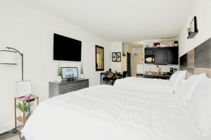 默特尔比奇Landmark Resort 1208的白色的卧室设有一张白色的大床和一间厨房