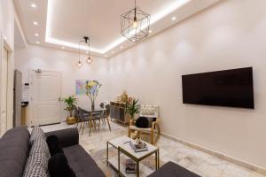 DerrouaAirport Apartment Suite Casablanca FREE WIFI Modern Confort Calme的客厅配有沙发和墙上的电视