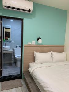 Ruifang晶晶輕旅民宿的一间卧室配有一张床,浴室设有卫生间