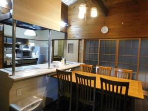 那须町貸別荘「ブライト那須」的一间带桌椅的用餐室和一间厨房