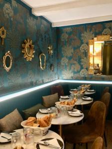 翁弗勒尔Reglisse et Pain d'Epices - Chambres d'hôtes的餐厅的一排桌子,椅子和镜子