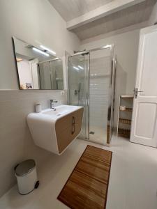 莱切Suite Battisti 7的一间带水槽、淋浴和镜子的浴室