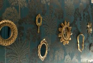 翁弗勒尔Reglisse et Pain d'Epices - Chambres d'hôtes的蓝色壁纸上带金色镜子的墙