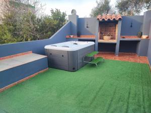 卡瓦内斯Casa vacacional Lavernia的一个带热水浴缸和绿草的庭院