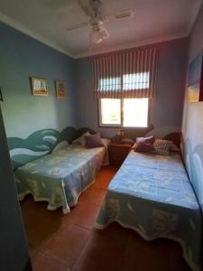 韦尔瓦Adosado playa Islantilla campo de golf的一间卧室设有两张床和窗户。