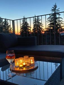 斯塔勒斯普拉维All about the Lake的阳台上的桌子上放着一杯葡萄酒和蜡烛