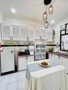 瓜埠QV Residence Langkawi - Jacuzzi, BBQ, & Steamboat的厨房里配有一张桌子,上面有盘子的食物