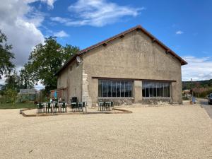 Montigny-sur-lʼAinLa Chambre du Tonneau的前面设有桌椅的建筑