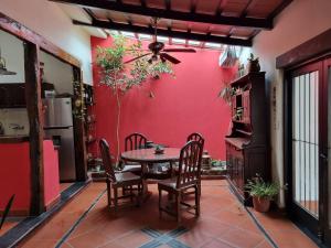 萨尔塔Hostal las Rosas的一间设有红色墙壁和桌椅的用餐室
