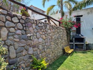 萨尔塔Hostal las Rosas的石墙,带长凳和灯