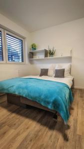 赖恩海姆Stilvolles Apartment mit Parkplatz, barrierefrei的一间卧室配有一张带蓝色毯子的大床