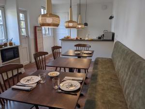 博讷Le 14 Faubourg的用餐室配有木桌、椅子和灯