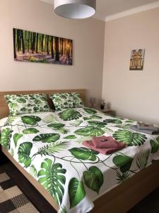 上塔尔卡尼Panoráma Apartman Felsötárkány的一间卧室配有一张带绿色和白色棉被的床