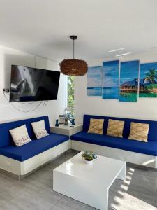 BocapánDeplaya Zorritos-Tumbes的客厅配有蓝色的沙发和电视