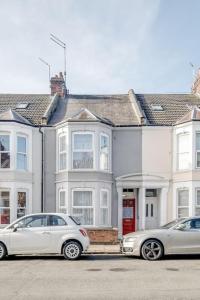 北安普敦Spacious Home - Ideal for Contractors的两辆汽车停在白色房子前面