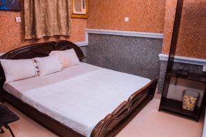 伊凯贾Double One Suites & Lodge的一间卧室配有一张带木制床头板的床