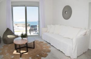 拉多斯Elements Villas的客厅配有白色的沙发和桌子