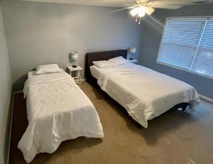 诺克斯维尔Beautiful Private West Knoxville Home 2700sf, 4 Beds, 2 & half Baths的一间卧室配有两张床和吊扇