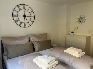 因斯布鲁克Gemütliche Wohnung mit Gartenblick的一间卧室配有大时钟和床上毛巾